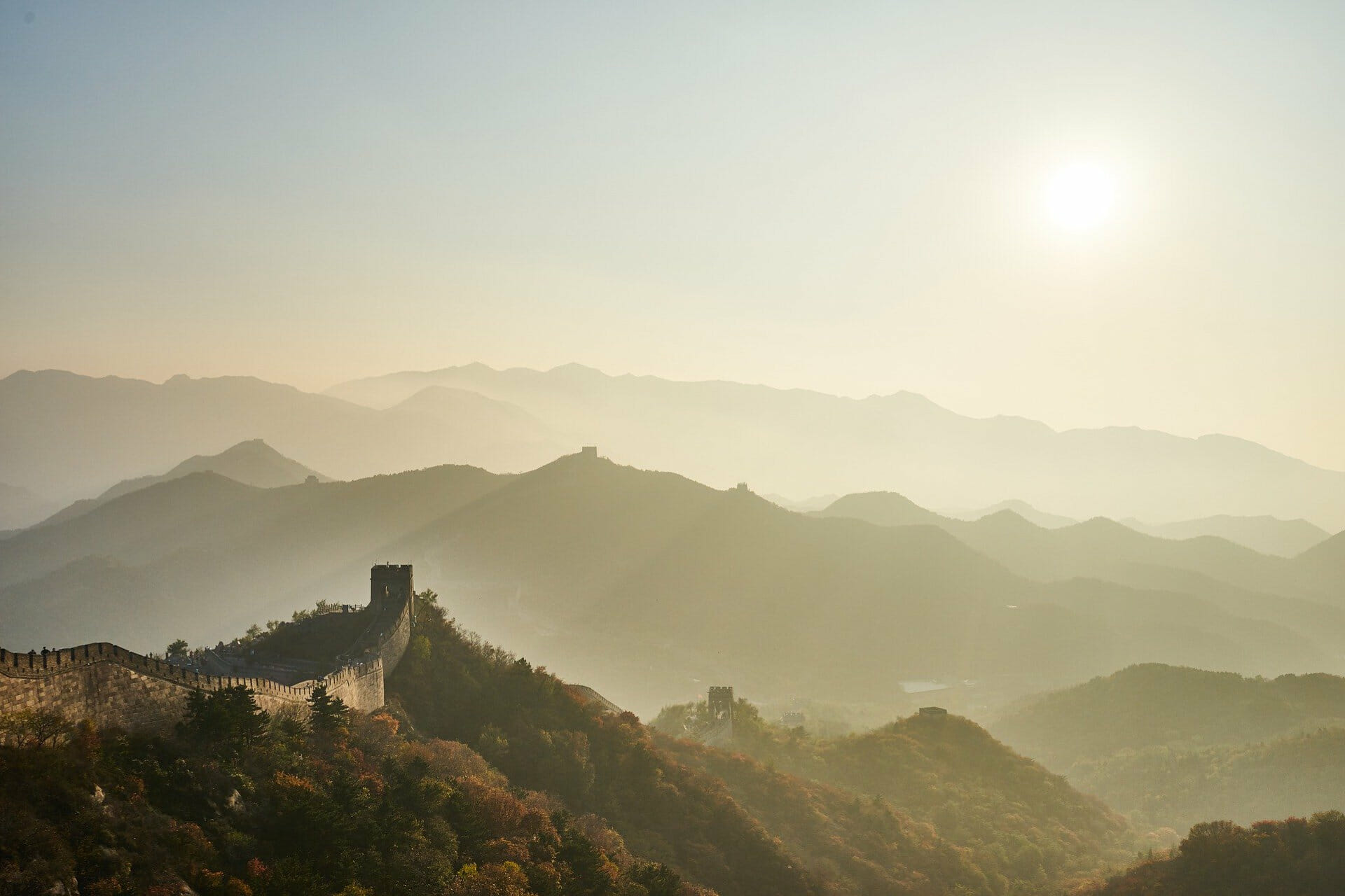 Great wall of China with sun in the sky and foggy haze